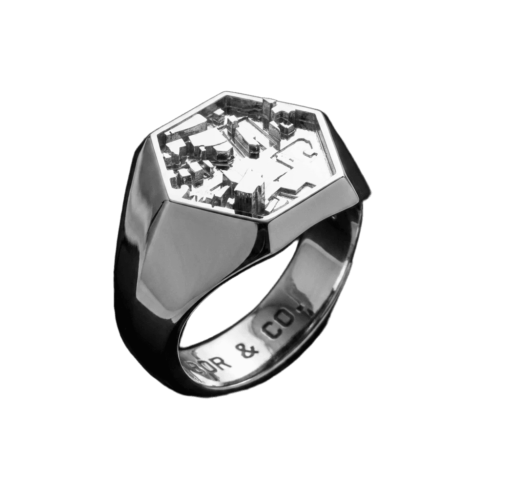 925 sterling silver hexagon signet ring with Shibuya / Tokyo building relief on the table, mirror-polished finish, background removed.